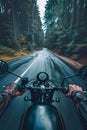 Closeup of two hands on motorcycle handlebars, motorcyclist on paved road