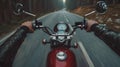 Closeup of two hands on motorcycle handlebars, motorcyclist on paved road