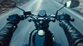 Closeup of two hands on motorcycle handlebars, motorcyclist on paved road