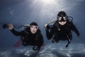 Closeup of two happy scuba divers holding their regulators in their hands underwater