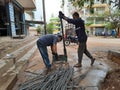 Closeup of two indian young man wear mask and cutting the hexagon window rod manually in the road side during lockdown, covid 19