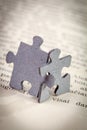 Closeup of Two Jigsaw Puzzle Pieces on Page of a Book Royalty Free Stock Photo