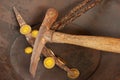 Closeup of two mining picks with new shiny gold coins in old gold mining pan. Looks like crypto currency.