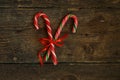 Closeup of two old fashioned candy canes on a rustic wooden back