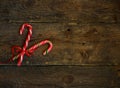 Closeup of two old fashioned candy canes on a rustic wooden back