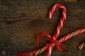 Closeup of two old fashioned candy canes on a rustic wooden back