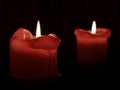 Closeup of two red candles burning on a dark background Royalty Free Stock Photo