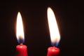 Closeup of two red candles burning in the dark Royalty Free Stock Photo