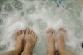 closeup on two sets of feet facing each other in a bubbly hot tub Royalty Free Stock Photo