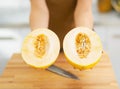 Closeup on two slices of melon in hand of woman