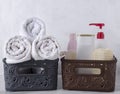 Closeup of two storage boxes full of fresh white towels and shower bottles against white wall Royalty Free Stock Photo