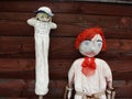 Closeup. Two. Two vintage, antique, handmade rag dolls, garden scarecrows, a red boy and a girl. Royalty Free Stock Photo