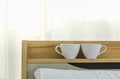 Closeup of two white cup of hot coffe on shelf over bed in bedroom morning Royalty Free Stock Photo