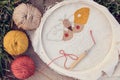 Closeup of unfinished embroidered butterfly on two-thread cloth with three multicolored cotton yarn balls and a charged punch Royalty Free Stock Photo