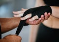 Closeup of unknown mixed race trainer wrapping caucasian boxers hands in gym. Hispanic coach getting kickboxer ready Royalty Free Stock Photo