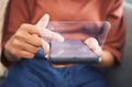 Closeup of unknown mixed race woman sitting alone at home and using her cellphone to browse a concept cgi internet