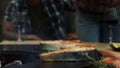 Woman chef salting fish on grill outside. unknown woman pouring salt on fish