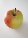 Closeup of a unpealed yellow green red apple on a light background