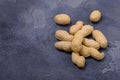 Closeup unpeeled peanuts on stone background