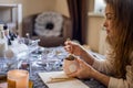 Closeup unrecognizable female hands relaxing hot tea beverage mug lying on bed with paper notepad