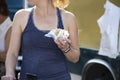 Closeup of unrecognizable girl in sleveless teeshirt with exercise wristband eating food from food truck outdoors Royalty Free Stock Photo