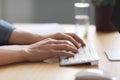 Closeup of unrecognizable man typing on computer keyboard while sitting at desk Royalty Free Stock Photo