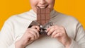 Closeup Of Unrecognizable Plump Girl Eating Milk Chocolate Bar And Smiling