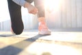 Closeup of unrecognizable sport woman tying sports shoes during evening run outdoors