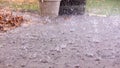 Closeup up view of a rain drops falling on a concrete patio on a background of a house. Royalty Free Stock Photo