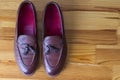 Closeup Upper View of Two Pair of Traditional Formal Stylish Brown Pebble Grain Tassel Loafer Shoes On Wooden Surface