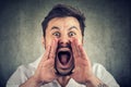 Closeup of upset, angry man with hands close to wide opened mouth yelling Royalty Free Stock Photo