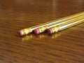 Closeup of used pencil erasers on wooden table Royalty Free Stock Photo