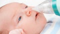 Closeup of using nasal aspirator for cleaning newborn baby nose from mucus. Concept of babies and newborn hygiene and