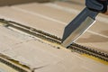 closeup of a utility knife cutting through cardboard