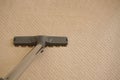 Closeup of the vacuum cleaner gray tube and brush on the carpet Royalty Free Stock Photo