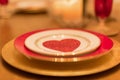 Closeup of Valentine`s Day place setting by candlelight