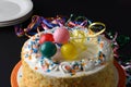 Closeup vanilla birthday cake with balloons and plates