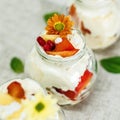 Closeup of vanilla ice cream with multiple fruits in a cute glass jar decorated with flowers