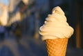 Vanilla Soft Serve Ice Cream Cone with Blurry Walking Street in Background Royalty Free Stock Photo