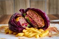 Closeup of vegetable gourmet burger with meat, caramelized onion, tomato, bacon, French fries Royalty Free Stock Photo