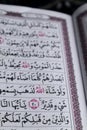 closeup on the verses of the Quran or Koran. focus on the red lafadz allah text Royalty Free Stock Photo