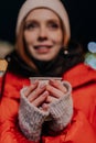 Closeup vertical selective focus portrait of charming young woman wearing warm winter clothes enjoying drinking takeaway Royalty Free Stock Photo