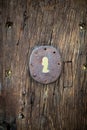 Closeup vertical shot of an old wooden door with a rusty keyhole Royalty Free Stock Photo