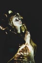 Closeup vertical shot of a praying angel statue in the darkness Royalty Free Stock Photo