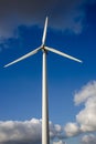 Closeup vertical shot of a single windmill for electric power production with a cloudy sky behind Royalty Free Stock Photo