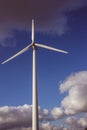 Closeup vertical shot of a single windmill for electric power production with a cloudy sky behind Royalty Free Stock Photo