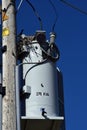 Closeup vertical shot of a wooden power pole with an electrical transformer under a clear sky Royalty Free Stock Photo