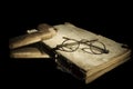 Closeup very old spectacles eyes glasses with wooden box on very old open book lying on mirror for reflection Royalty Free Stock Photo