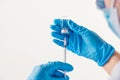 Closeup vial and needle of covid-19 vaccine in hand of scientist doctor in laboratory for treatment with mask gloves and lab coat