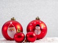 Closeup of vibrant red Christmas ornaments with Santa Claus and a snowman on them Royalty Free Stock Photo